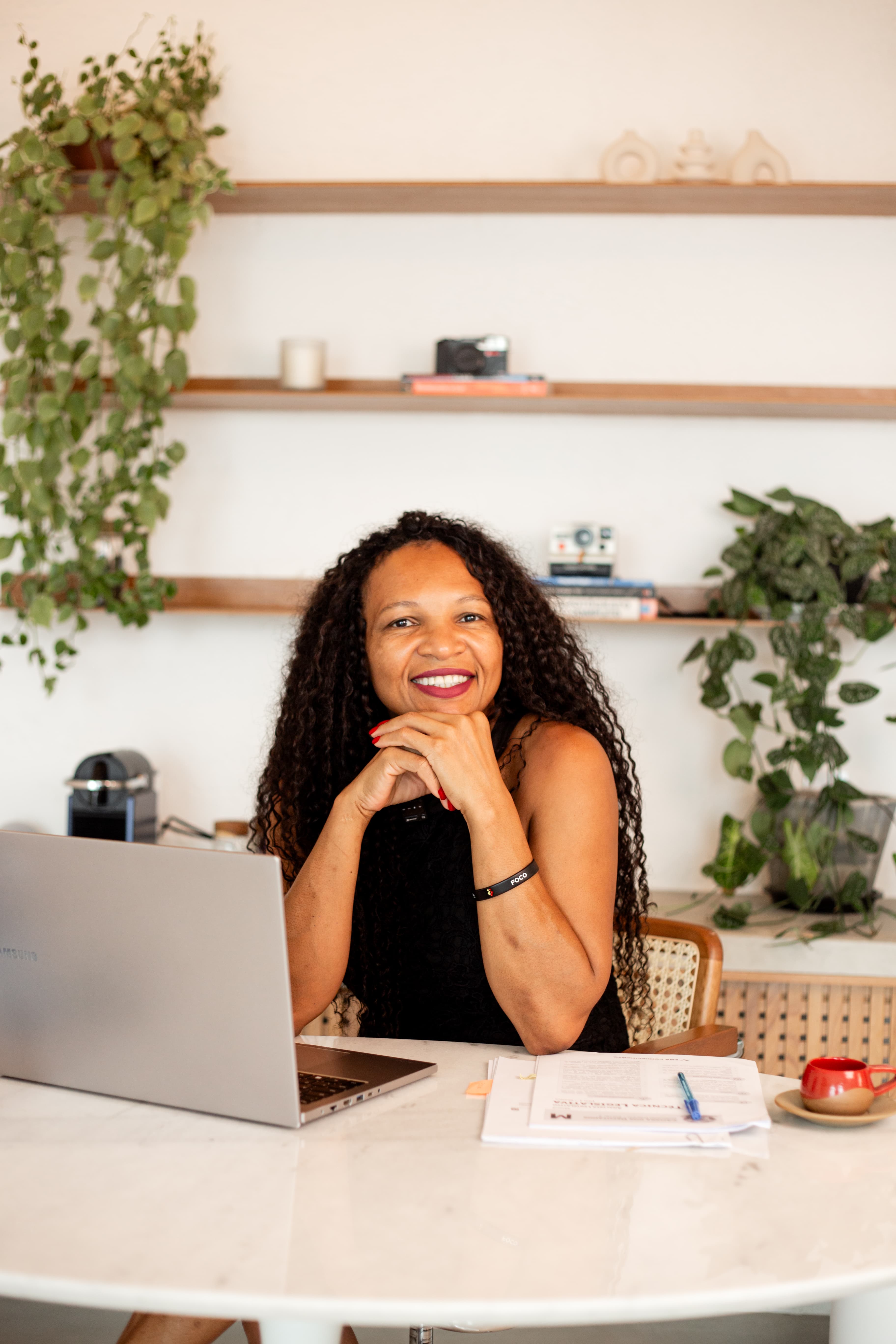 Professora Cleidimar Sousa sorrindo na mesa de estudos